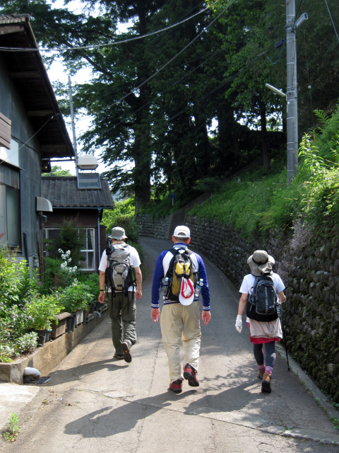 駅からの道を登山口へ向けて登っていく3人の後ろ姿