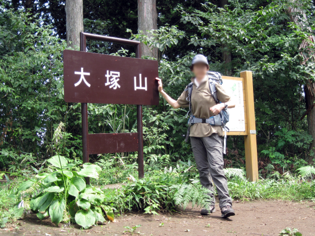 大塚山の山頂にて、山名の看板脇に建つ隊員