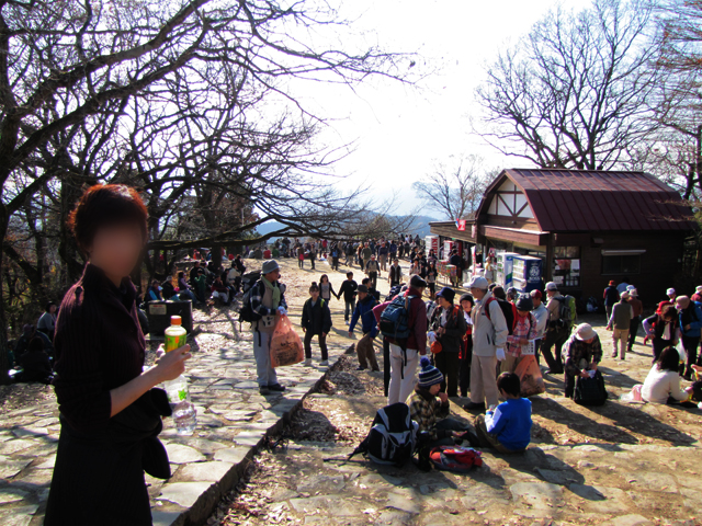 人がたくさんいる高尾山頂。登山の格好や普段着や、いろんな格好をした人がいます。