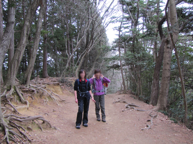 登山道の途中で立ち止まってポーズをとる二人